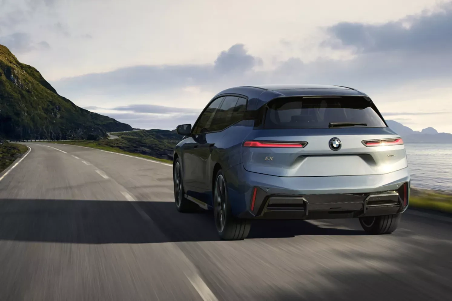 Une BMW iX conduisant vers l'horizon, l'océan en arrière-plan.