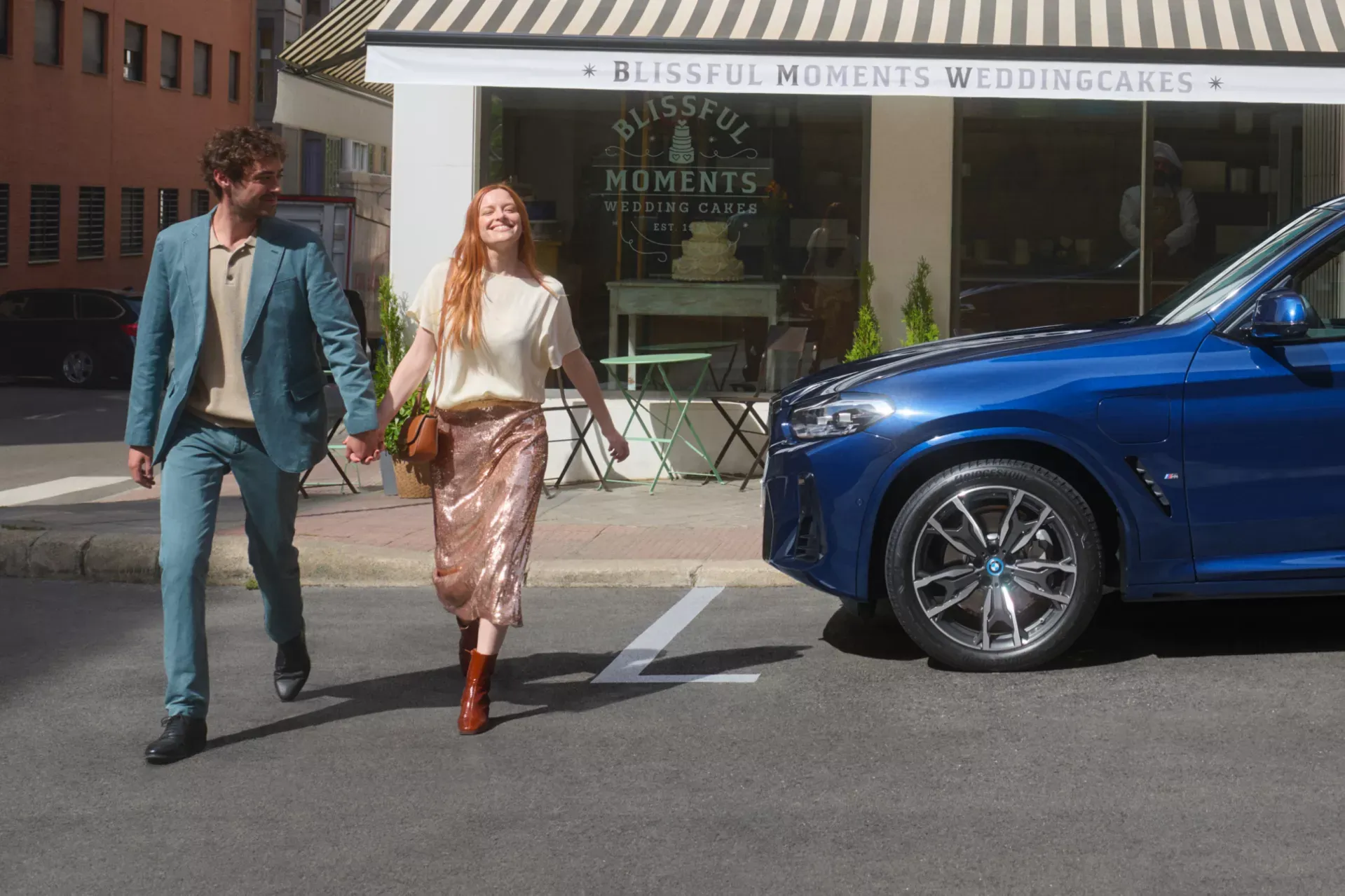 Un couple devant leur véhicule BMW.