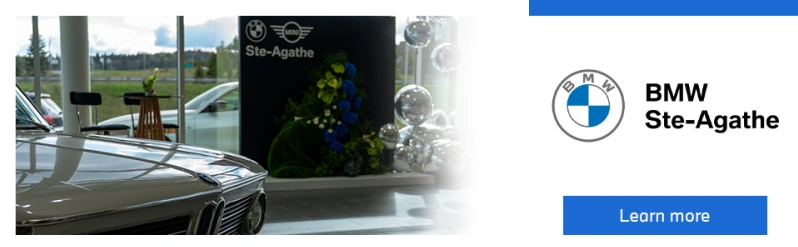 Interior view of BMW – MINI Ste-Agathe dealership with a displayed car and floral installation.